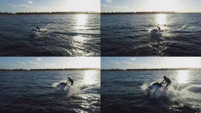 4k鸟瞰图，男子在海洋中乘坐私人船只玩得开心，太阳落在海浪上，莫桑比克