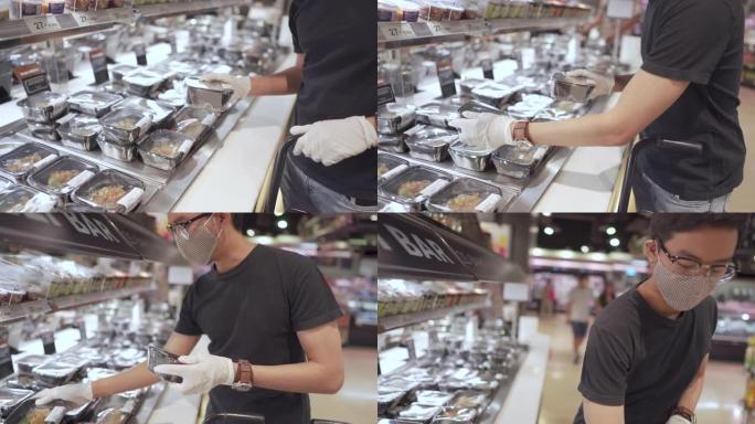 亚洲男子戴着防护手套和口罩在超市购买午餐盒。