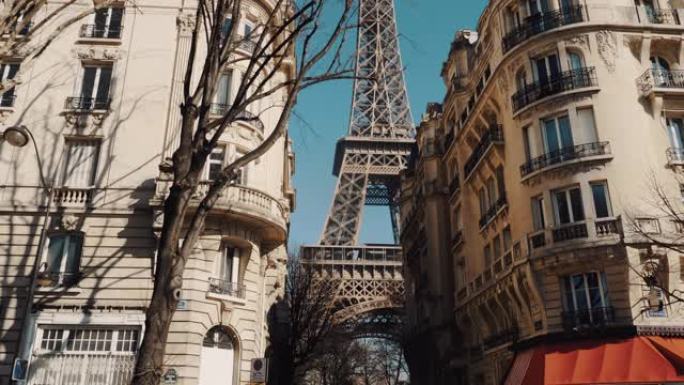 相机沿着公寓楼的树后滑动，在阳光明媚的秋天早晨巴黎展现史诗般的埃菲尔铁塔。