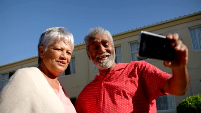 活跃的非洲裔美国老年夫妇在前卫用手机自拍的低角度视角