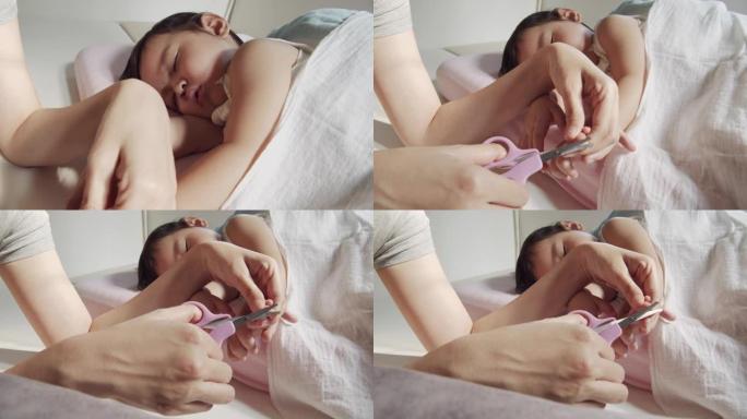 妈妈在家用指甲剪在婴儿身上剪指甲的特写镜头。婴儿身体护理概念。特写镜头前视图