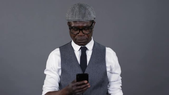 时尚的非洲男子在智能手机上发短信