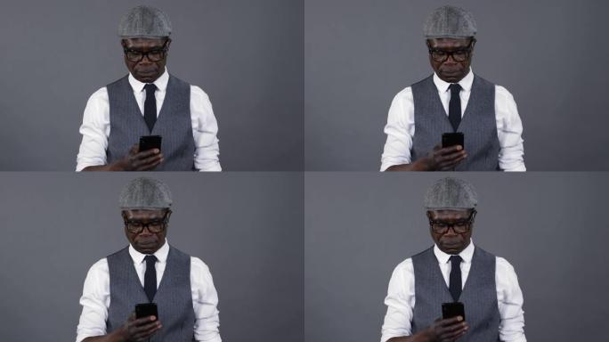 时尚的非洲男子在智能手机上发短信