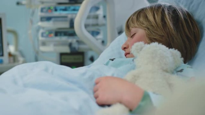生病的男孩在急诊室与泰迪熊一起睡觉