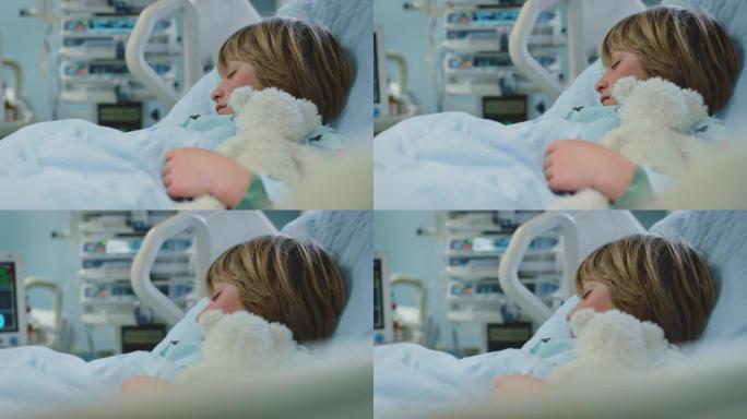 生病的男孩在急诊室与泰迪熊一起睡觉