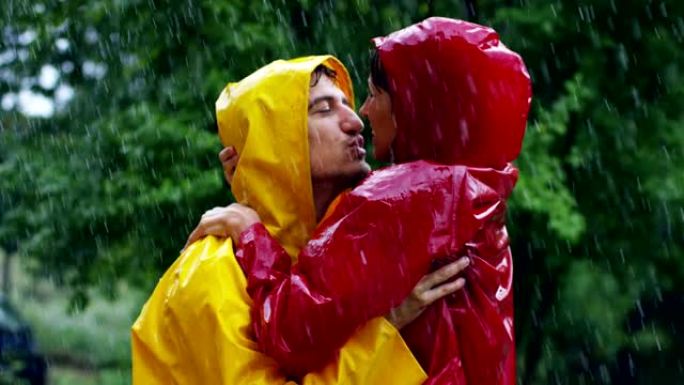 一对情侣，恋爱中的男人和女人在大自然的雨中跳舞，亲吻和玩耍快乐的微笑。自由和爱。