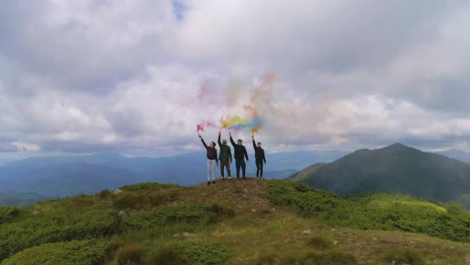 带彩色烟雾弹的四人站在山顶上