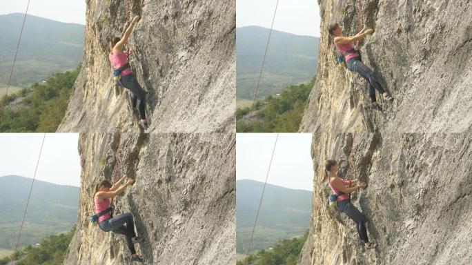 无畏的女攀岩者在阳光明媚的夏日攀登巨大的悬崖。