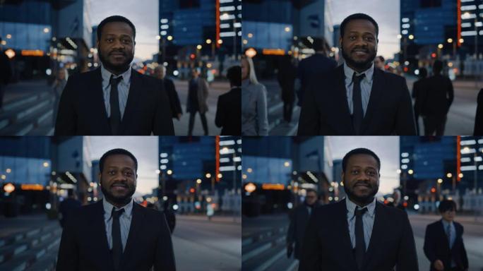 一个穿着西装的非洲裔美国商人的肖像，站在街上，有行人。他看起来很成功，微笑着。今天是傍晚，背景是大气