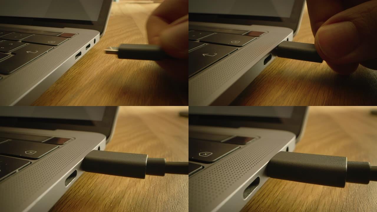 特写微距拍摄: 笔记本电脑放在桌子上，人将usb-c电缆适配器插入计算机端口。