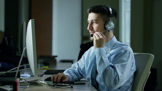 一个在客户服务部门或在某个机场控制塔站工作的年轻人，日夜微笑着接听电话给客户打电话。