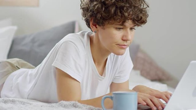 Woman Drinking Coffee and Working from Bed