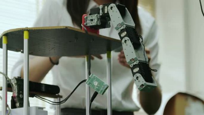 青少年在学校机器人俱乐部项目的全功能可编程机器人上工作。创意设计师在车间测试机器人原型。科学概念。行