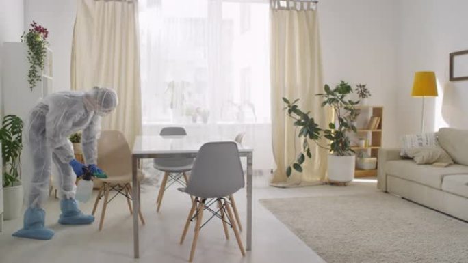 在家穿着防护服消毒椅的女人