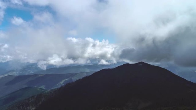 在风景如画的山脉上方的云流中飞行。过度下垂