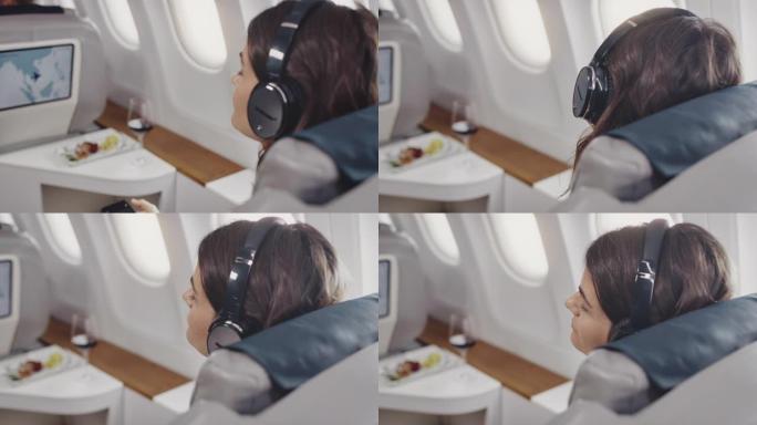 女商人在公司飞机上听音乐