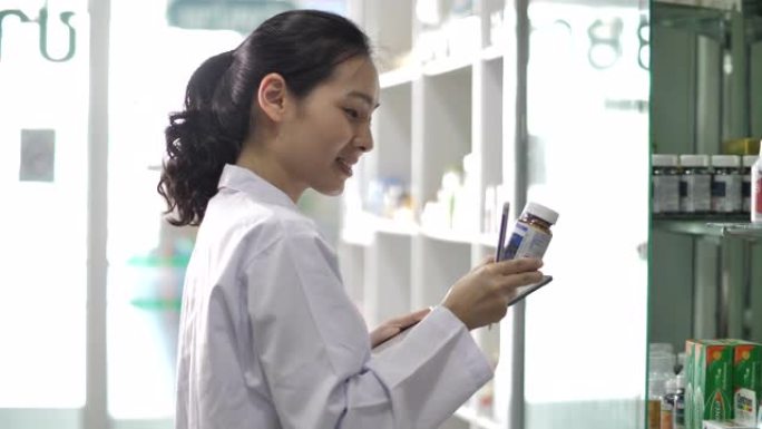 亚洲药剂师使用数字平板电脑在药房工作