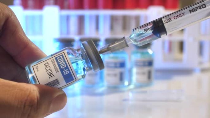 医疗手和注射器正在为实验室中的患者接种疫苗