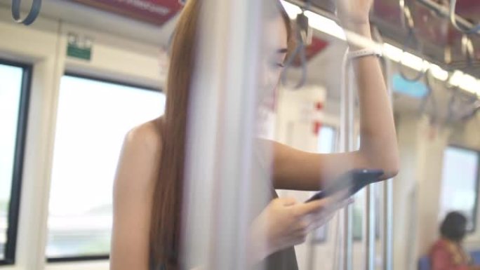 一位年轻女士在公共汽车上使用智能手机