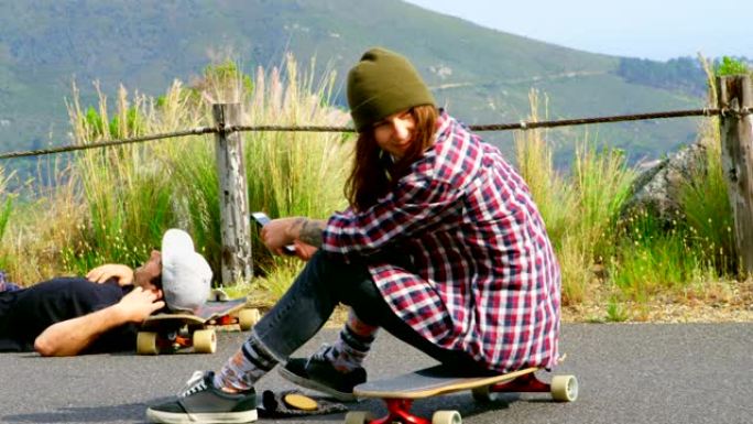 阳光明媚的4k，年轻的高加索滑板手在滑板上放松的侧视图