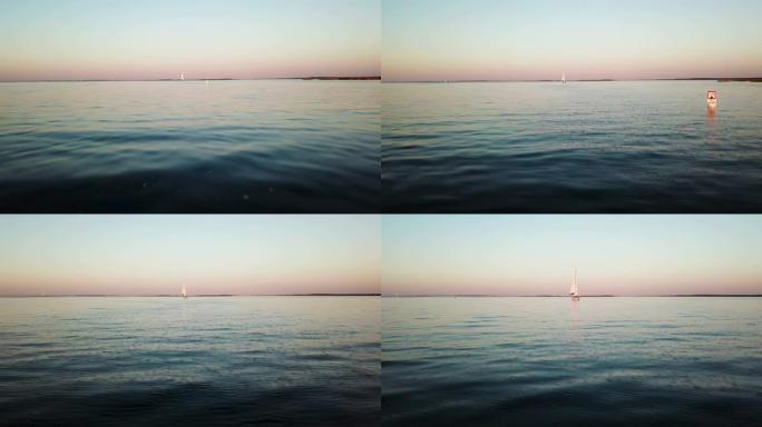 缓缓漂浮在湖上的帆船鸟瞰图。日落