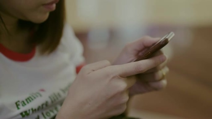 年轻女子在咖啡馆使用智能手机。