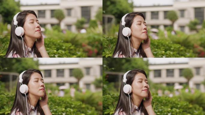 一位年轻女子正在公园里闭着眼睛欣赏音乐