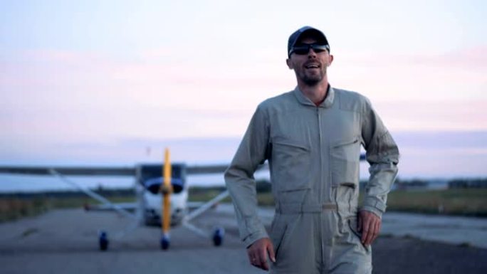 一名飞行员在飞机背景上的跑道上行走，特写镜头。