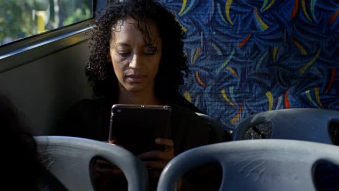 在公交4k中使用数字平板电脑的女性通勤者