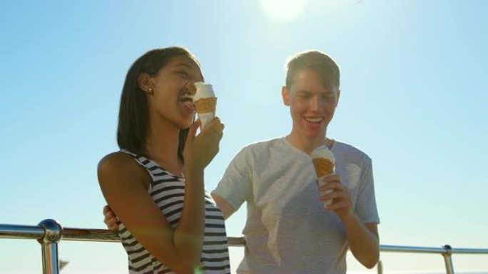 快乐的年轻夫妇在4k栏杆附近吃冰淇淋