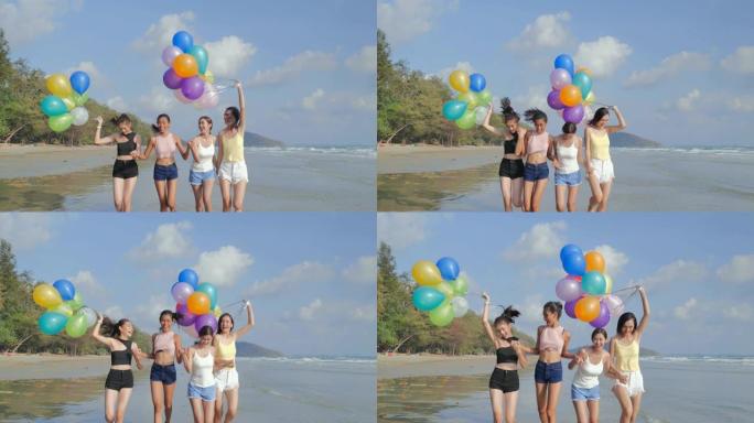 一群女朋友带着气球在蓝天的背景下在海滩上散步。幸福的朋友在夏日阳光明媚的阳光下在海滩上玩耍。假期-i