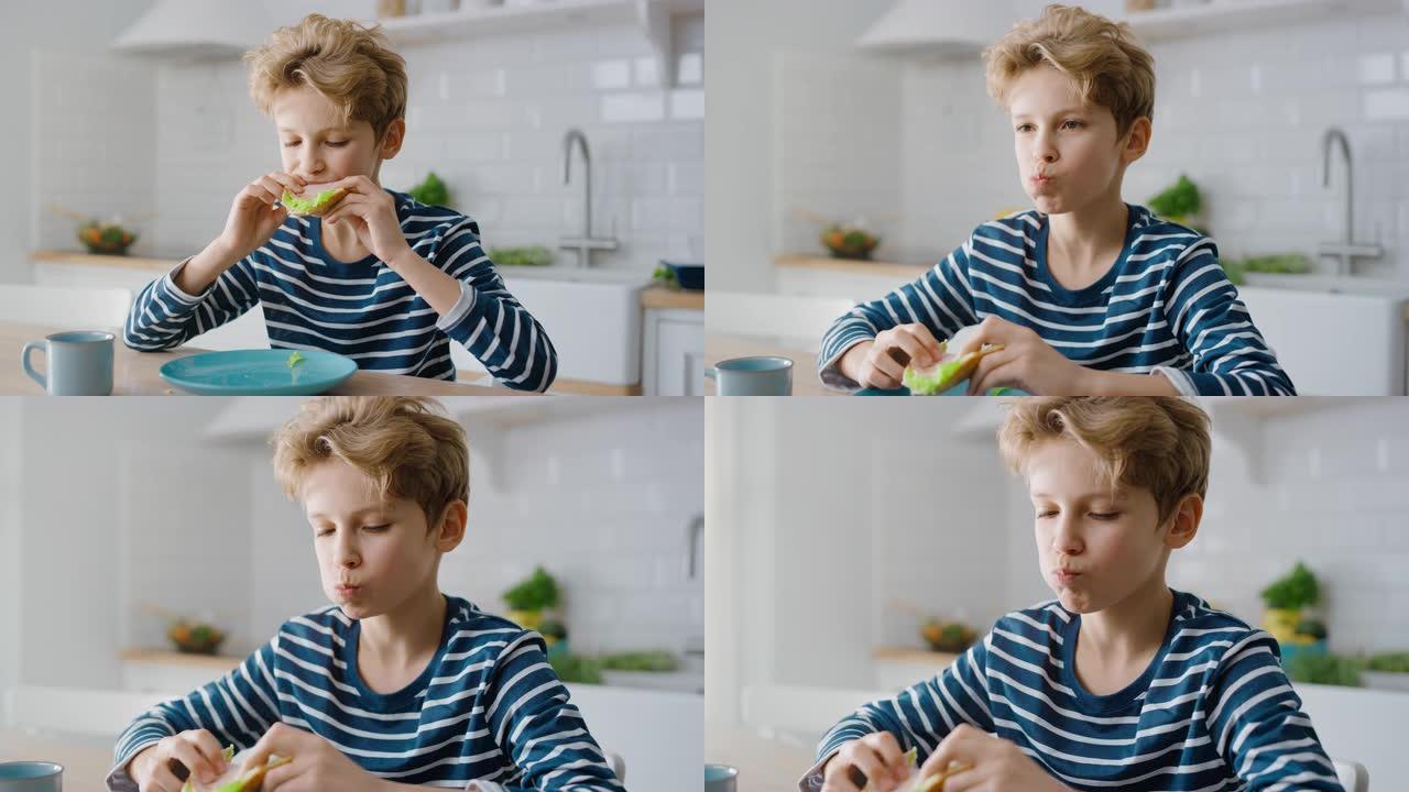 可爱的小男孩在厨房餐桌上吃三明治的肖像。帅哥吃一口健康零食