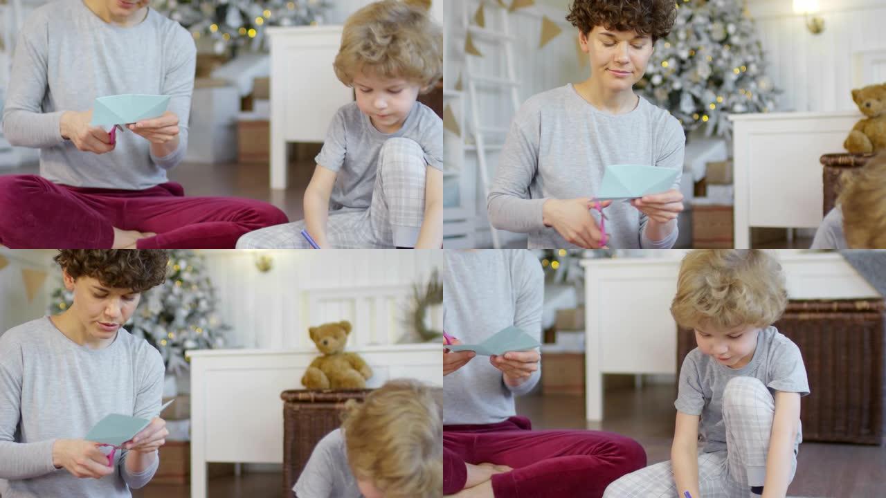 小男孩和他的母亲在家为圣诞节做纸质装饰品