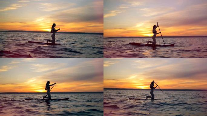 日落背景上的冲浪女孩，侧视图。女运动员在冲浪板上划着桨。