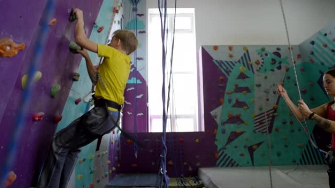 高加索少年与女教练练习攀岩