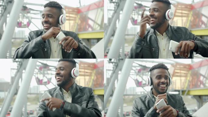 快乐的非裔美国人戴着耳机在城市户外玩得开心