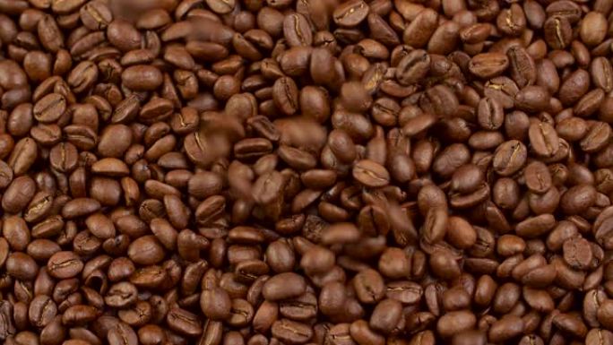 烤棕色咖啡豆背景。许多豆子从上面慢慢落下。慢动作镜头