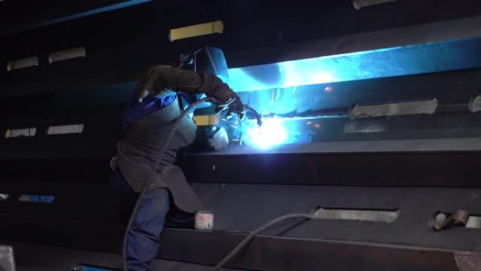 拉丁美洲男子建造一个大的金属结构焊接一块