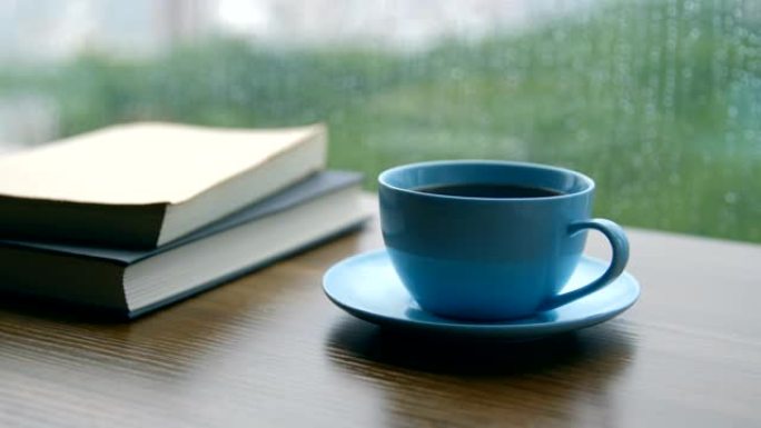 雨天在木桌上看书和咖啡杯