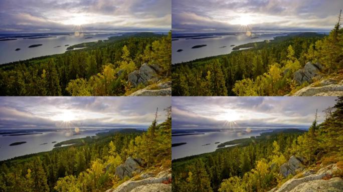 芬兰科利国家公园的日出。太阳光线穿过皮利宁湖上空的灰色云层。森林山脉。UHD