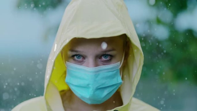 超级SLO MO覆盖在一个戴着面具的雨衣女人身上