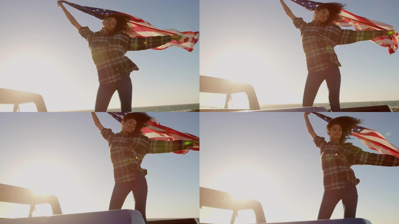 女人在4k海滩的皮卡车上挥舞着美国国旗