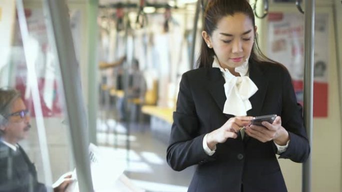 在地铁上使用智能手机的女商人。