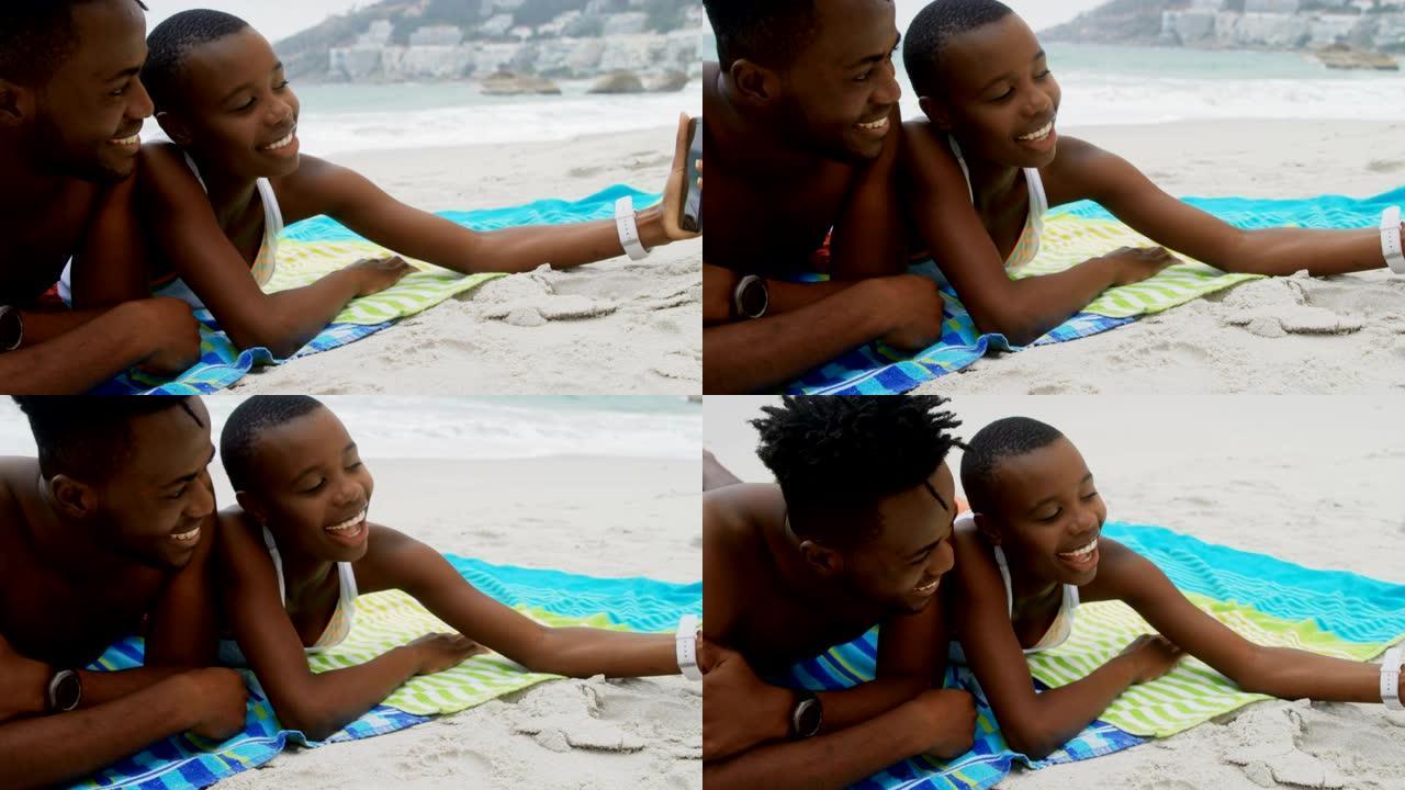 非裔美国夫妇在海滩上用手机自拍的前视图4k