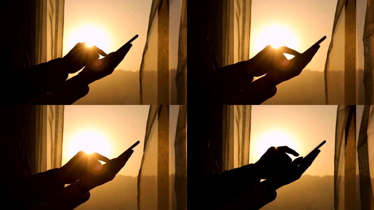 男子手在日落时使用手机