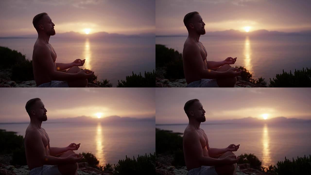 男人冥想。日落时的岩石海岸线