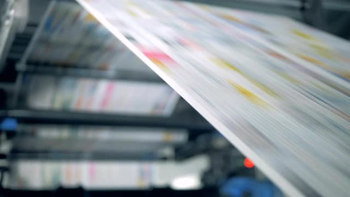 报纸在印刷输送机上滚动，自动生产。
