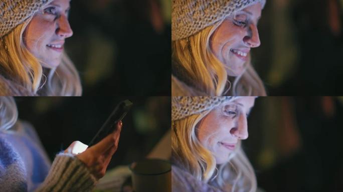 女人晚上在智能手机上发短信的特写镜头