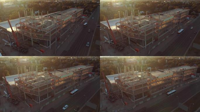 鸟瞰图: 工业/商业物业建筑工地。日出中的机械和摩天大楼混凝土模板框架