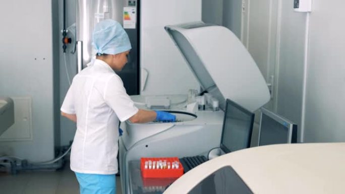 护士使用现代自动化医疗设备进行血液检查。